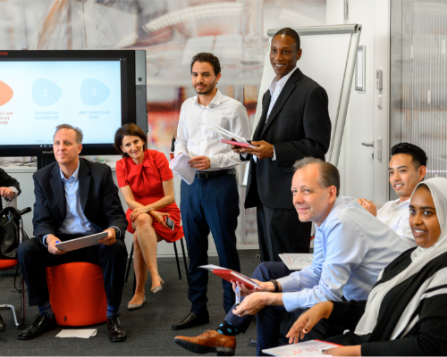 Un equipo diverso de Henkel se sienta en un taller y observa al orador