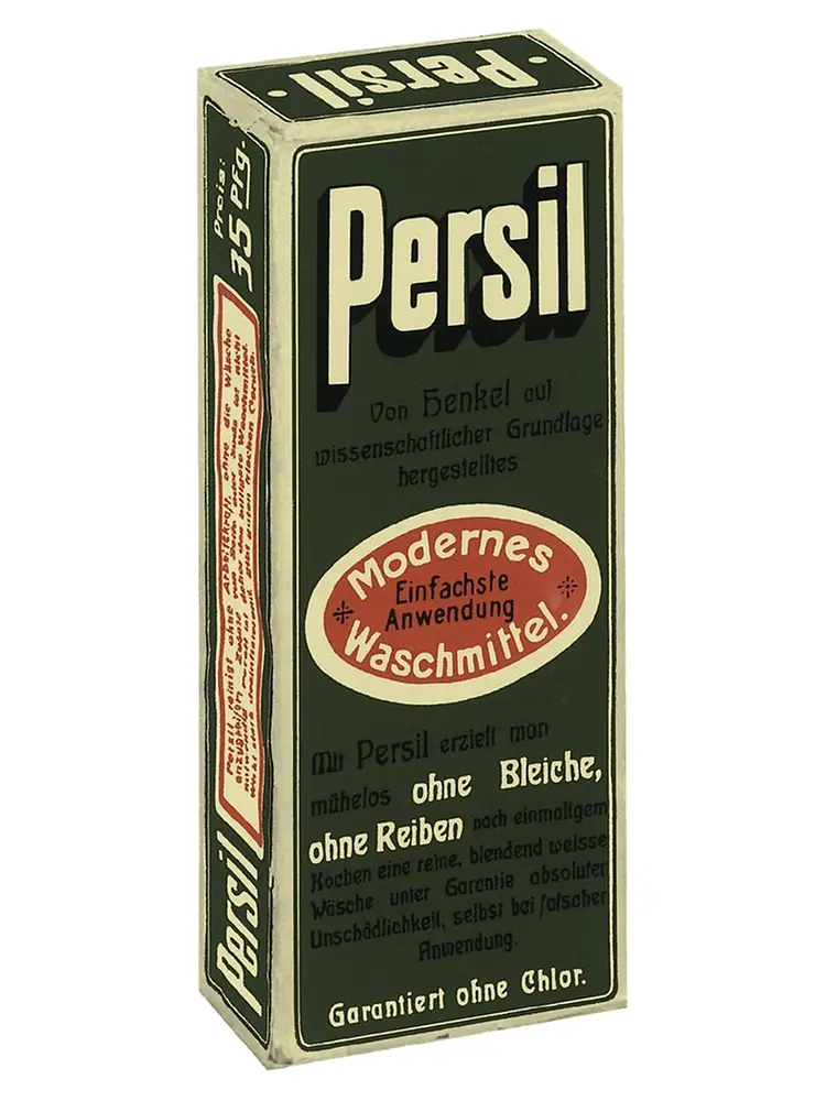 Caja vintage de detergente Persil con texto en alemán y etiqueta ovalada roja que destaca su aplicación moderna y fácil.