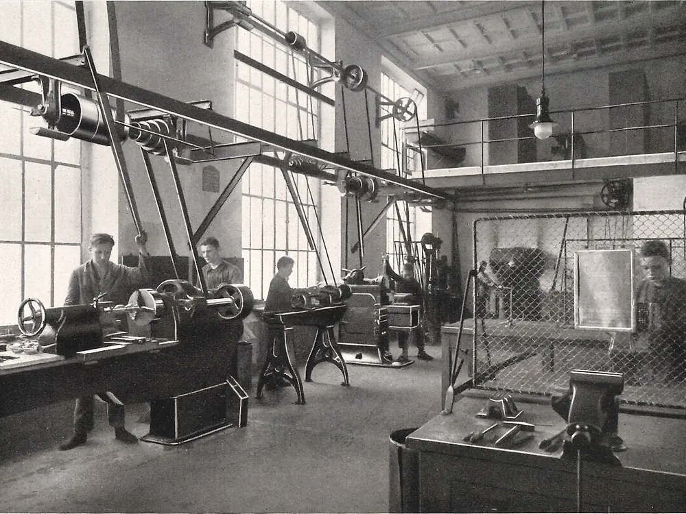 Aprendices trabajando con máquinas en el taller de metalurgia.