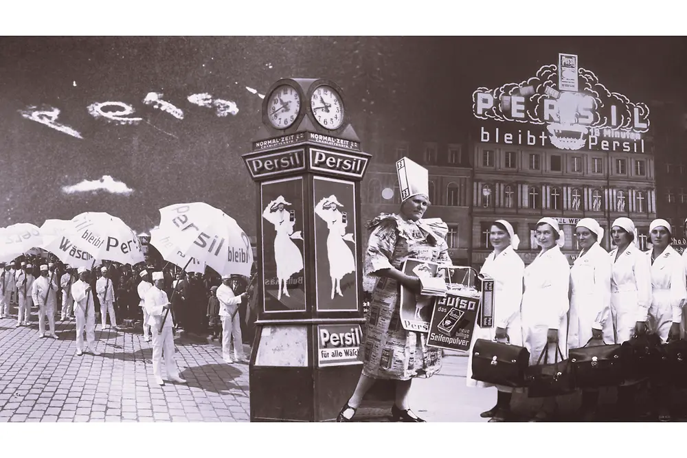 Collage publicitario vintage de Persil en el que aparecen personas con paraguas de la marca, un reloj decorativo con carteles y un edificio con el letrero iluminado de Persil al fondo.