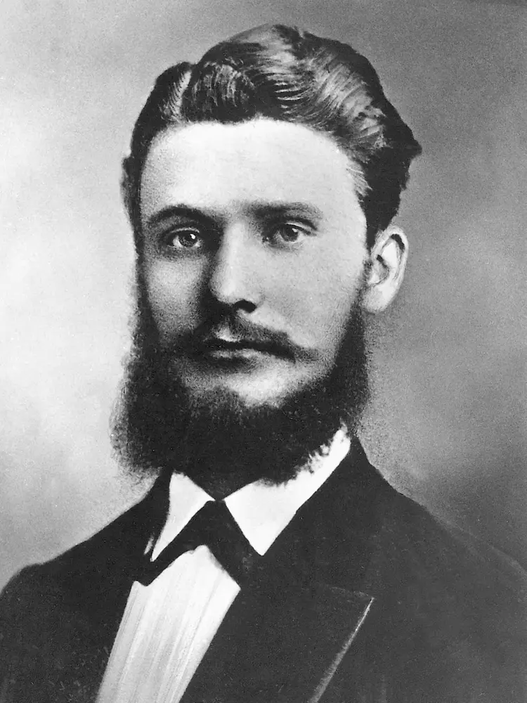 Retrato histórico en blanco y negro de Fritz Henkel con traje formal, barba completa y cabello cuidadosamente peinado.